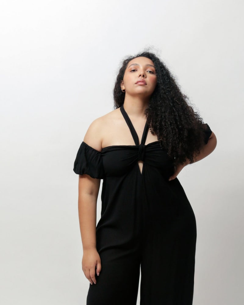 Front of a model wearing a size L Amelia Off The Shoulder Jumpsuit in Black by LuvMeMore. | dia_product_style_image_id:266604